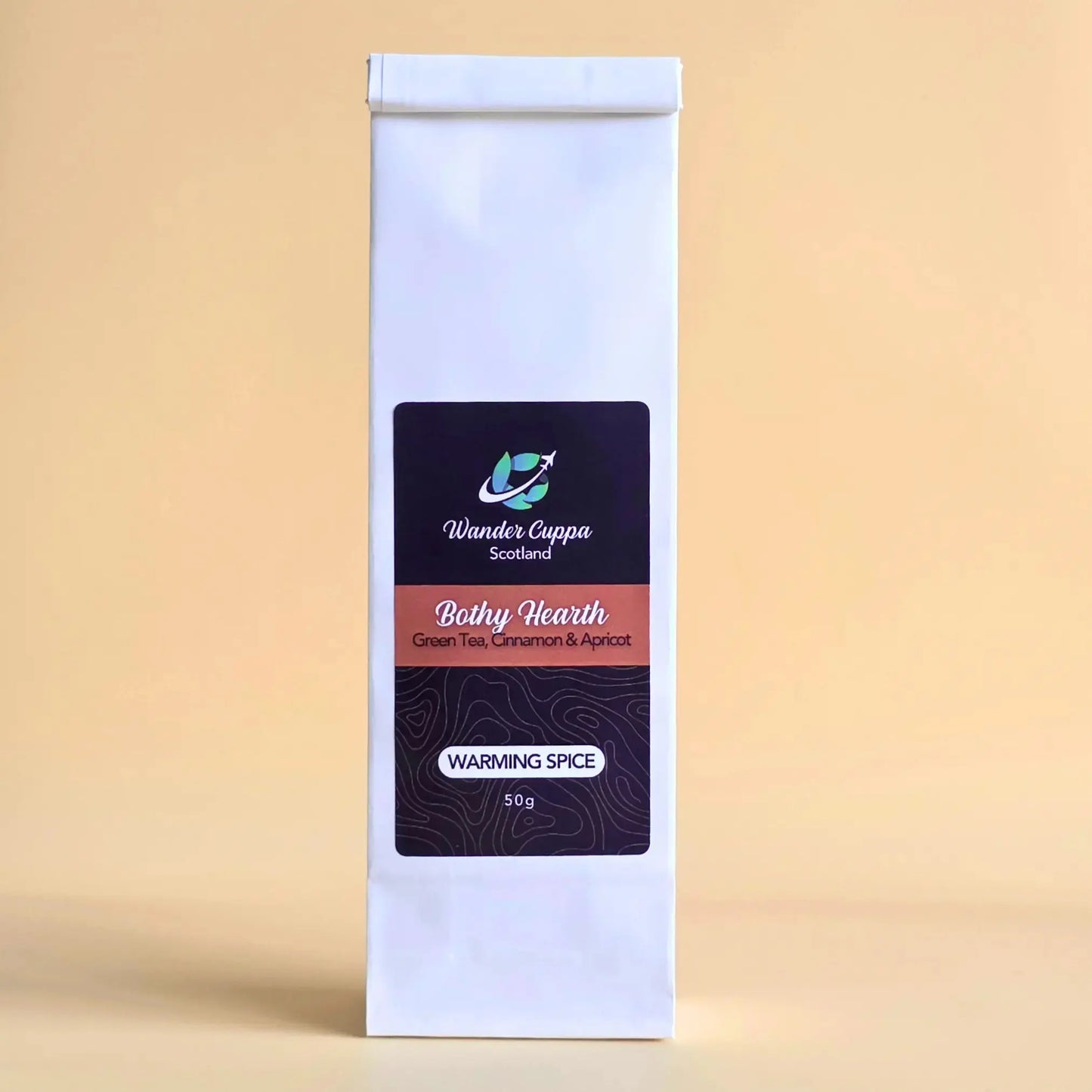 Bothy Hearth spiced green loose leaf tea with cinnamon ginger and pink pepper from Wander Cuppa. This premium tea is a warming green tea infusion inspired by Scottish fireside moments, perfect for a comforting cuppa tea or afternoon tea in Scotland. As a wholesale tea supplier UK, we provide this vegan tea and full leaf tea for cafes and retail across the UK. High-quality loose leaf tea near me featuring green tea leaves blended with aromatic spices and apricot pieces.