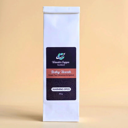 Bothy Hearth spiced green loose leaf tea with cinnamon ginger and pink pepper from Wander Cuppa. This premium tea is a warming green tea infusion inspired by Scottish fireside moments, perfect for a comforting cuppa tea or afternoon tea in Scotland. As a wholesale tea supplier UK, we provide this vegan tea and full leaf tea for cafes and retail across the UK. High-quality loose leaf tea near me featuring green tea leaves blended with aromatic spices and apricot pieces.
