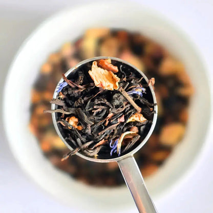 Glasgow Sunset black loose leaf tea from Wander Cuppa featuring rich cocoa beans and pear pieces. This premium tea is a decadent Scottish blend with rose petals and cornflower blossoms, ideal for a cosy afternoon tea or evening treat. As a wholesale tea supplier UK, we provide this vegan tea and full leaf tea for retail and cafes throughout Scotland and the UK. Authentic loose leaf tea near me with indulgent chocolate and fruit notes